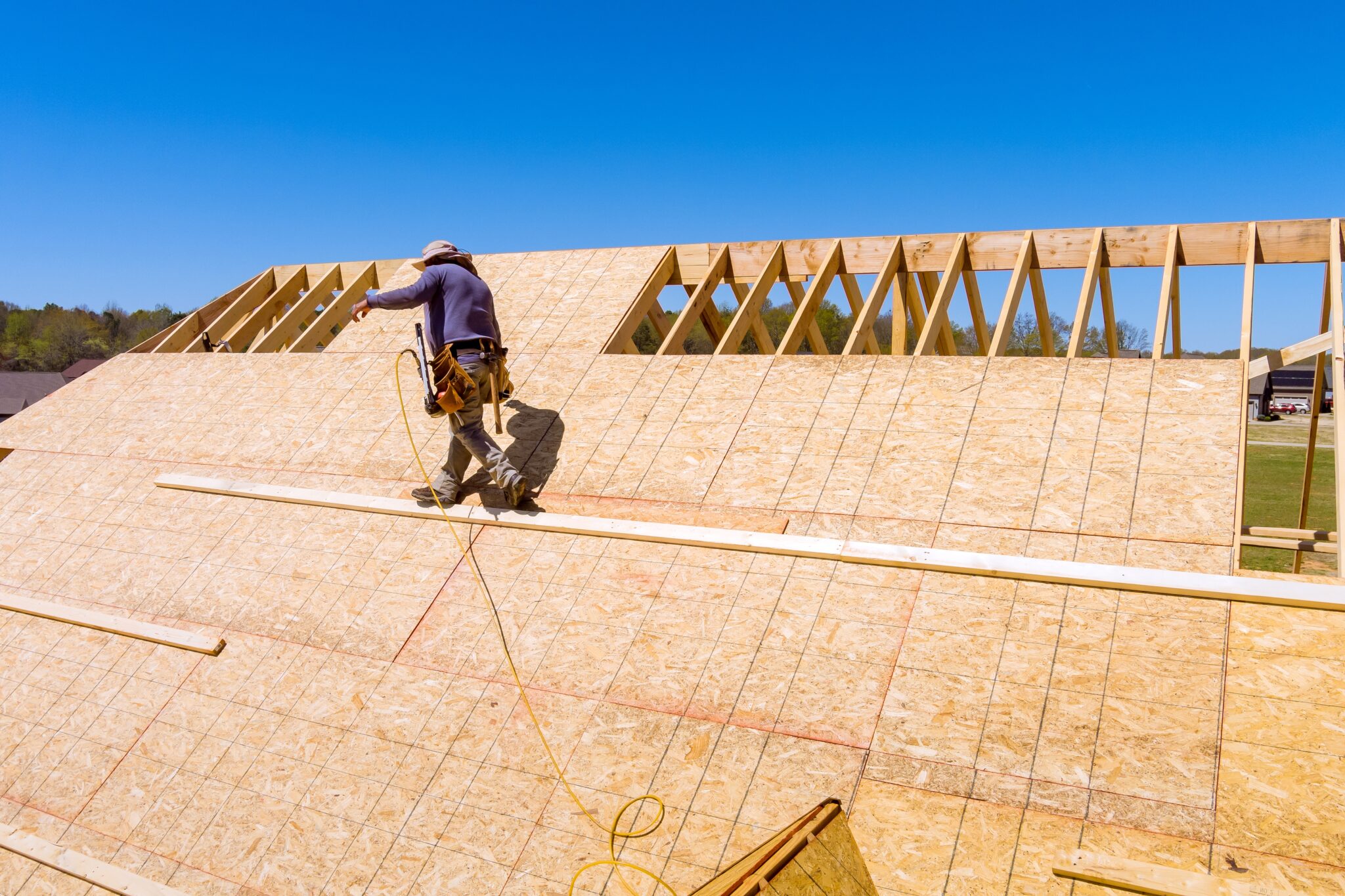 Aerial top view of home roof construction applying roof plywood panels in new house